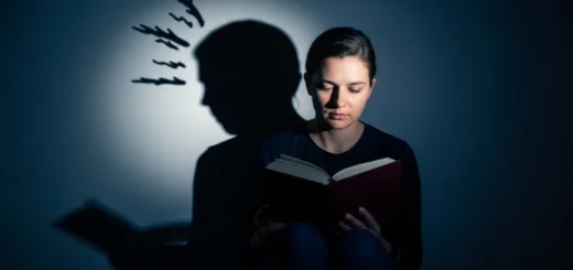 Pessoa lendo em ambiente escuro representando o arquétipo da sombra e o autoconhecimento