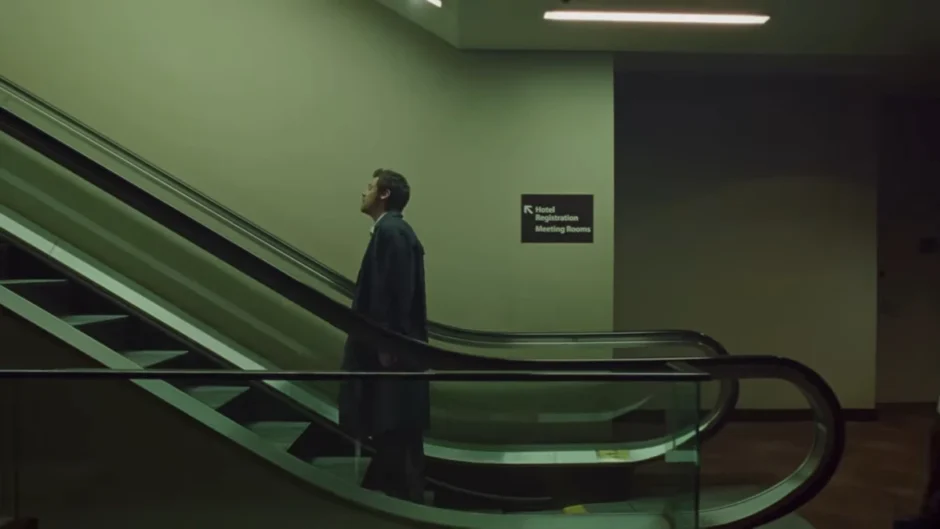 Frame do clipe “Aperture”, de Harry Styles: cantor em pé em uma escada rolante, em cenário urbano com luz fria e atmosfera cinematográfica.