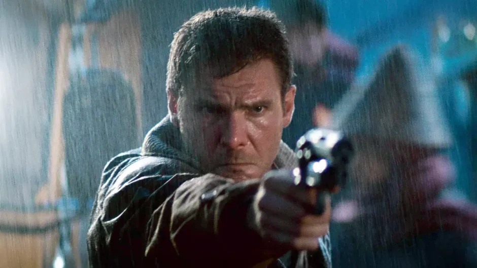 Rick Deckard aponta sua arma em cena de Blade Runner (1982), representando o conflito entre humanidade e replicantes