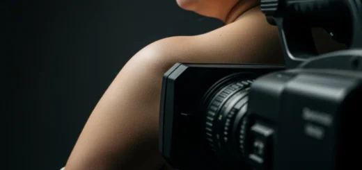 Câmera de televisão posicionada muito próxima ao corpo humano, sugerindo a invasão da intimidade física pelo dispositivo midiático.