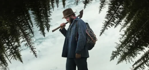 Joel Edgerton como Robert Griner com um machado na neve em cena do filme Sonhos de Trem (2024)