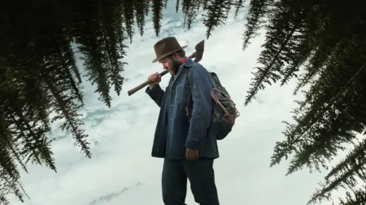 Joel Edgerton como Robert Griner com um machado na neve em cena do filme Sonhos de Trem (2024)