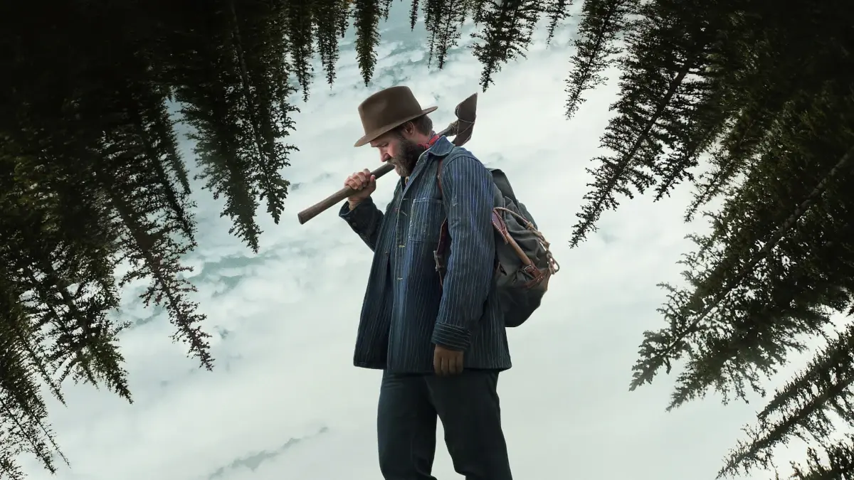 O Homem que a História Não Viu: Uma Crítica de Sonhos de Trem 1 Joel Edgerton como Robert Griner com um machado na neve em cena do filme Sonhos de Trem (2024)