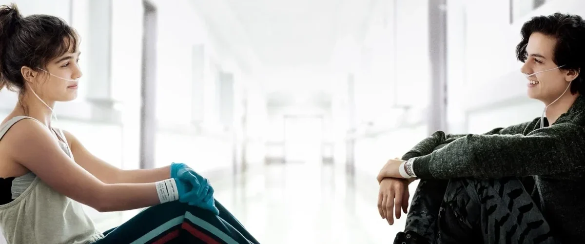 Dois jovens pacientes sentados à distância em corredor de hospital em A Cinco Passos de Você