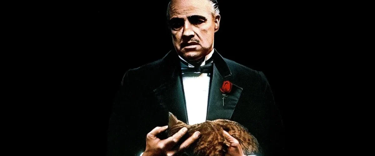 Vito Corleone segura um gato em cena de O Poderoso Chefão, símbolo da autoridade silenciosa e do poder simbólico no cinema
