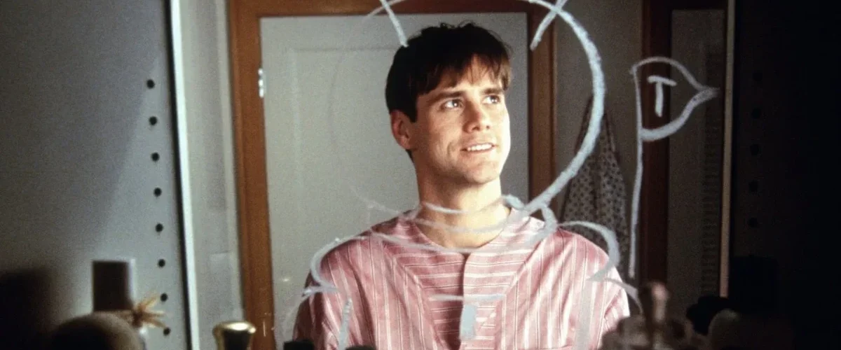 Jim Carrey jovem olhando para espelho com desenhos, simbolizando origem do humor