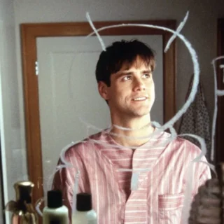 Jim Carrey jovem olhando para espelho com desenhos, simbolizando origem do humor