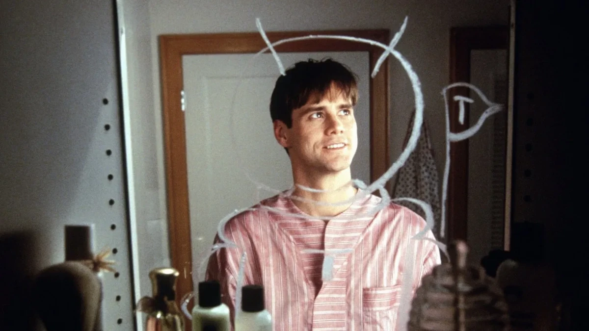 Jim Carrey jovem olhando para espelho com desenhos, simbolizando origem do humor