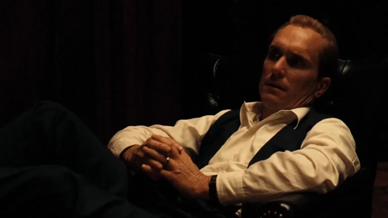 Tom Hagen Nunca Foi Consigliere: O Homem Invisível Que Salvou a Máfia 6 Robert Duvall como Tom Hagen em O Poderoso Chefão sentado em poltrona em cena do filme