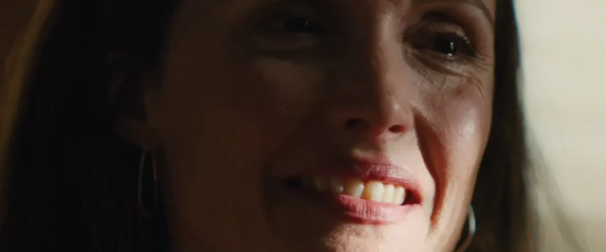 Close de Rose Byrne no filme Se Eu Tivesse Pernas Eu Te Chutaria, retratando o esgotamento emocional da maternidade