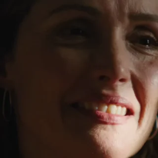 Close de Rose Byrne no filme Se Eu Tivesse Pernas Eu Te Chutaria, retratando o esgotamento emocional da maternidade