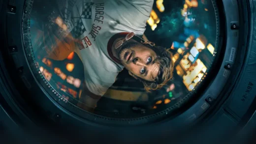 Ryan Gosling como Ryland Grace em Devoradores de Estrelas, observando pela escotilha de uma nave espacial