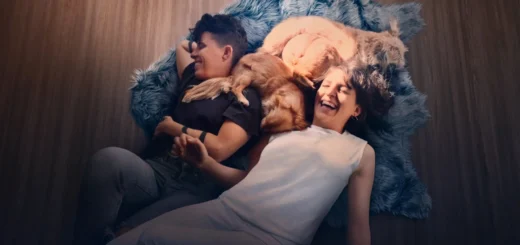 Casal de poetas deitado no chão com cães em cena do documentário Embaixo da Luz de Neon