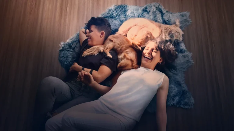 Casal de poetas deitado no chão com cães em cena do documentário Embaixo da Luz de Neon