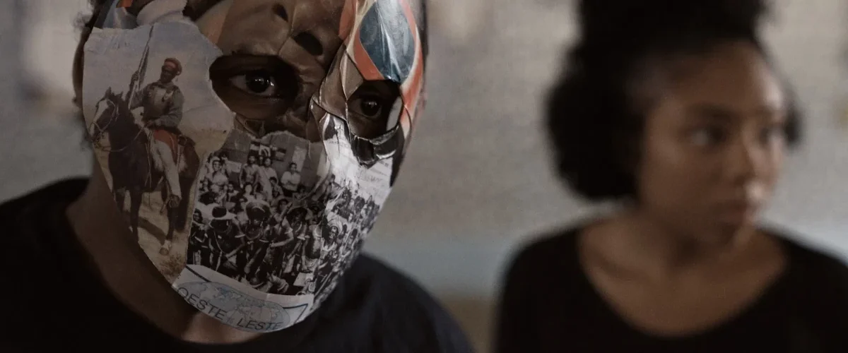 Jovem com máscara feita de recortes históricos em cena do documentário Hora do Recreio de Lúcia Murat
