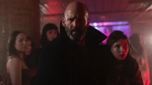 Jason Statham em cena do filme Missão Refúgio (2026) ao lado da jovem Jessie em ambiente iluminado por neon