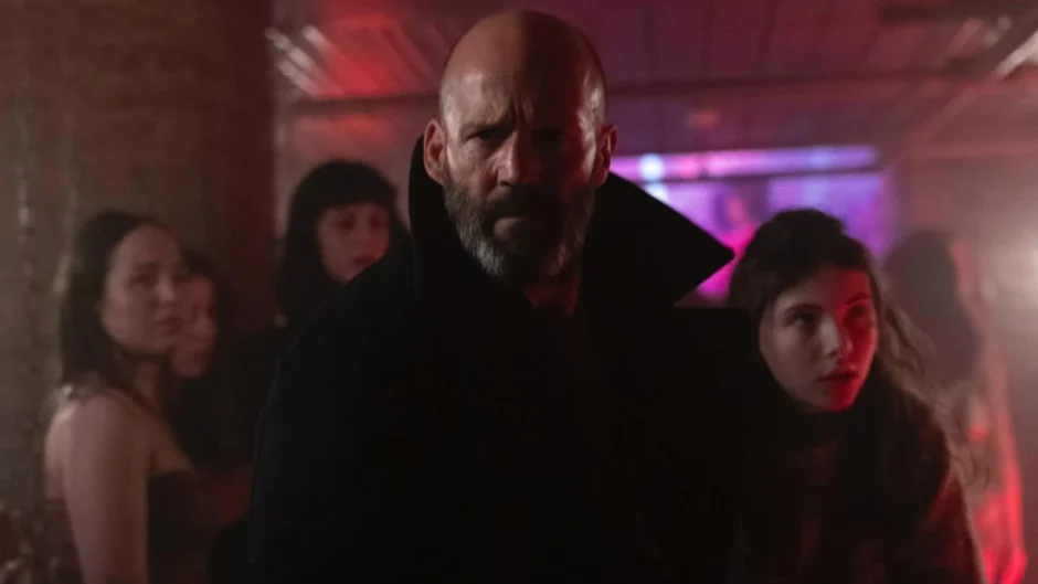 Jason Statham em cena do filme Missão Refúgio (2026) ao lado da jovem Jessie em ambiente iluminado por neon