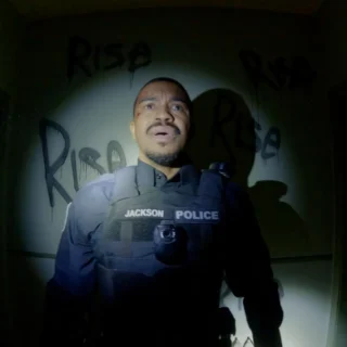 Policial com câmera corporal em cena do filme POV: Presença Oculta (Bodycam), terror found footage de Brandon Christensen.