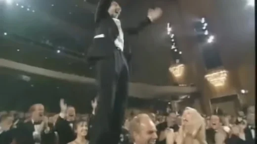 Roberto Benigni subindo nas cadeiras da plateia ao ganhar o Oscar de Melhor Ator por A Vida é Bela em 1999