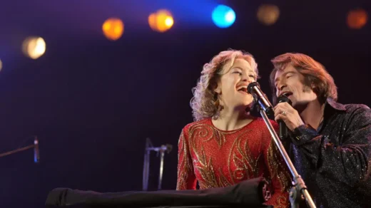 Hugh Jackman e Kate Hudson cantando no palco no filme Song Sung Blue Um Sonho a Dois