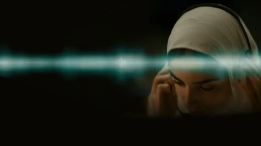 Mulher usando fones de ouvido escuta gravação em A Voz de Hind Rajab, com onda sonora atravessando a imagem