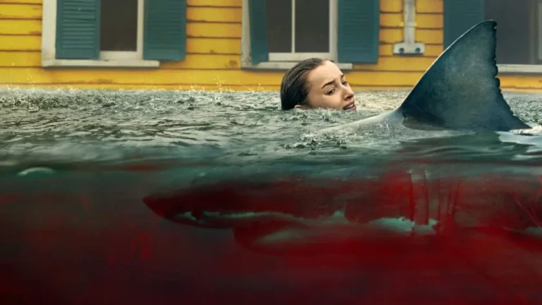 Cena do filme Ataque Brutal (2026) com mulher em água alagada sendo ameaçada por tubarão durante furacão na Netflix