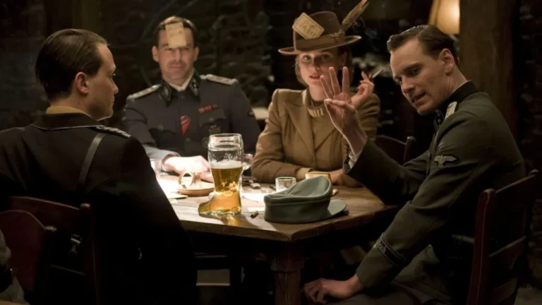 Cena da taverna em Bastardos Inglórios mostrando gesto dos três dedos que revela identidade do personagem