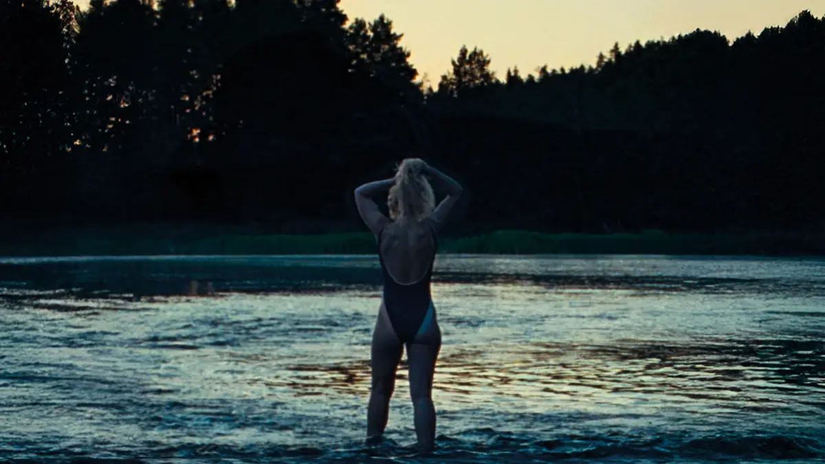 Cena do filme A Cronologia da Água com personagem entrando em lago ao entardecer