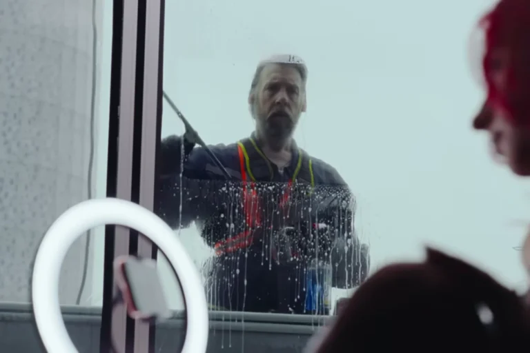 Window, do Foo Fighters: a música que transforma vulnerabilidade em riff (análise e significado) 4 Limpador de janelas observando interior através do vidro no clipe Window do Foo Fighters