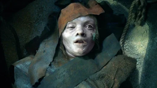 Garota mumificada com pele pálida e sinais de decomposição no filme Maldição da Múmia (2026)