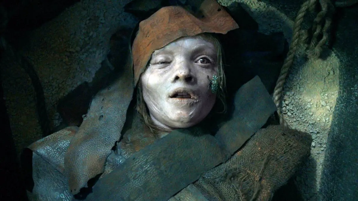 Garota mumificada com pele pálida e sinais de decomposição no filme Maldição da Múmia (2026)