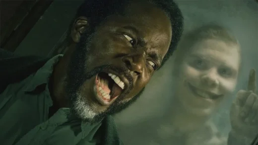 Boyd olhando para criatura sorridente na janela em From, simbolizando os monstros que imitam humanos