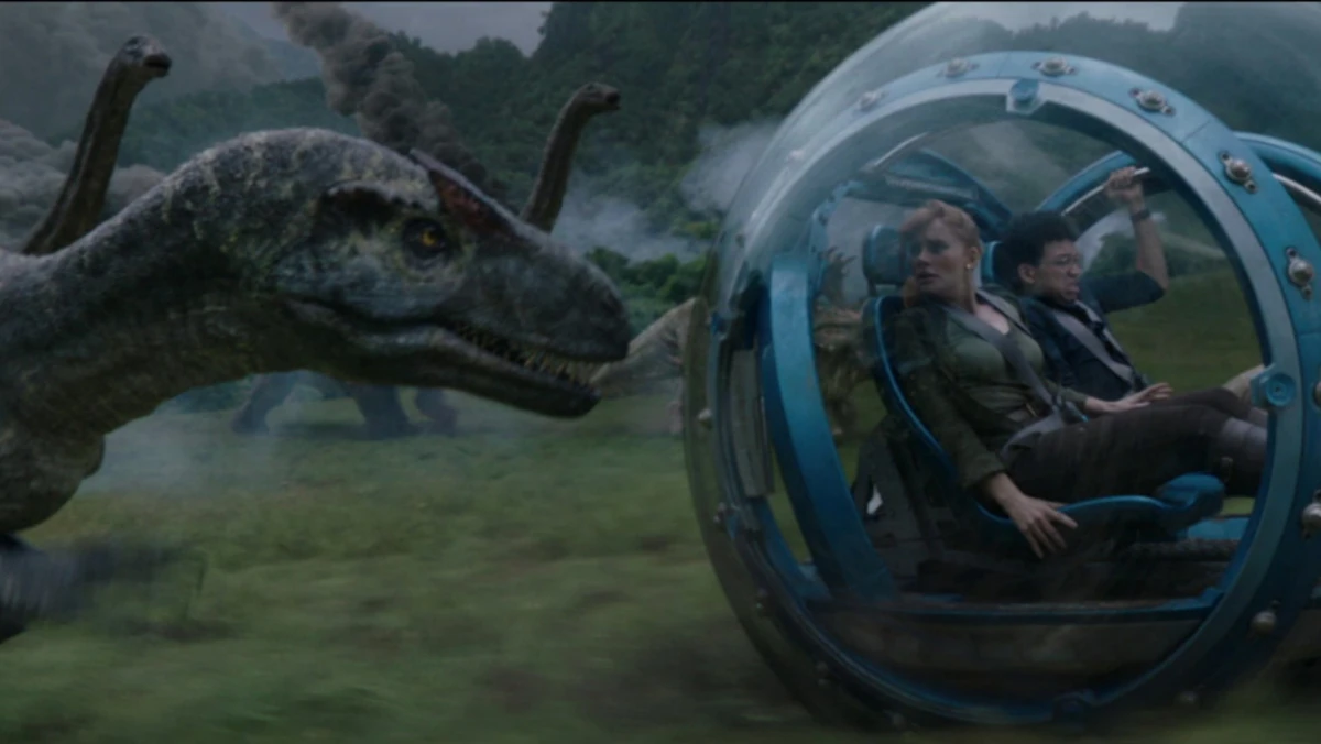 Cena de Jurassic World Reino Amea&ccedil;ado com dinossauro perseguindo personagens