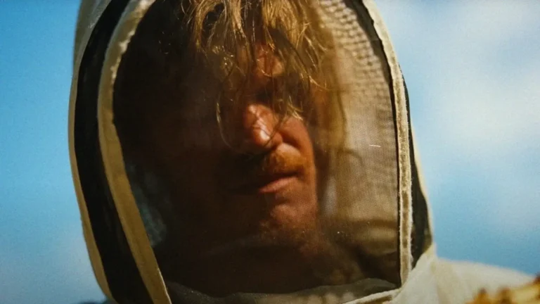 Bugonia: Yorgos Lanthimos e a Ciência que Vira Conspiração 1 Jesse Plemons usando traje de apicultor em cena do filme Bugonia, simbolizando o desaparecimento das abelhas e a paranoia ecológica.