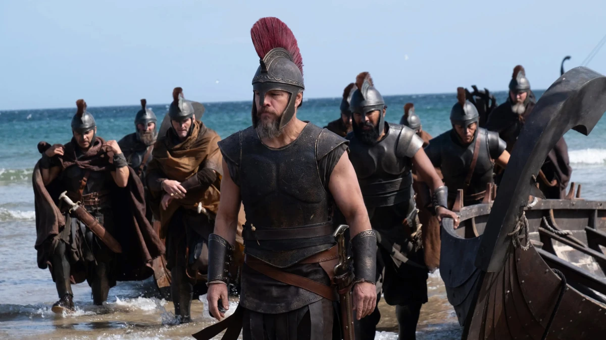 Odisseu e seus homens desembarcam em uma praia em cena de A Odisseia, filme de Christopher Nolan.
